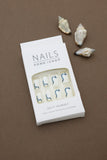 Elegant Waves: Minimalist White Nails Enhanced with Bold Blue Swirls – Perfect for a Chic and Modern Look!