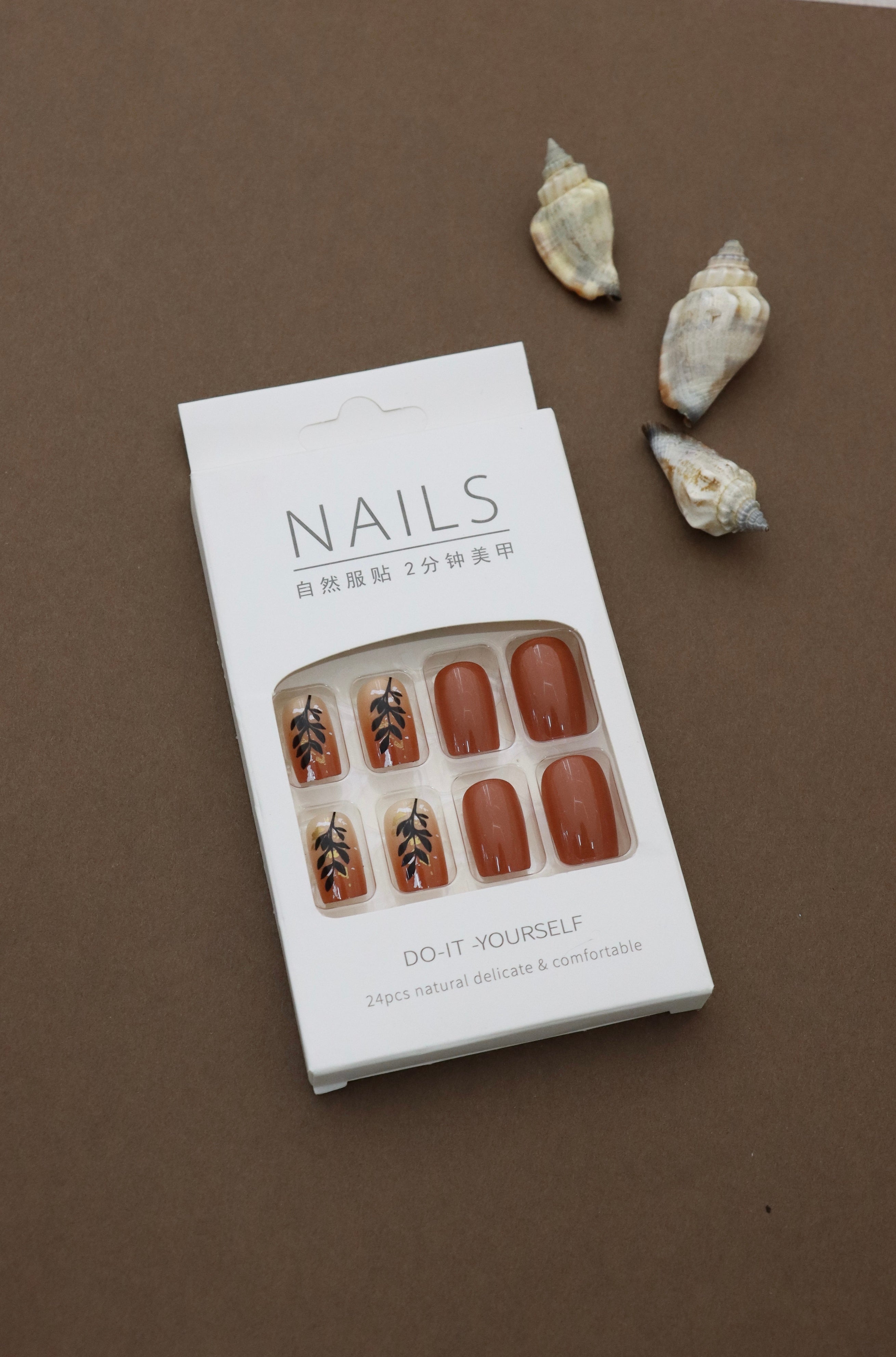 Warm & Earthy: Terracotta Nails with Elegant Black Leaf Art. Embrace Nature's Charm with a Stylish and Sophisticated Look. Perfect for an Autumn-inspired Vibe!