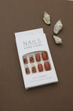 Warm & Earthy: Terracotta Nails with Elegant Black Leaf Art. Embrace Nature's Charm with a Stylish and Sophisticated Look. Perfect for an Autumn-inspired Vibe!